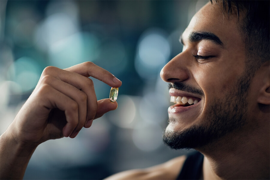 Young man taking a multivitamin pill